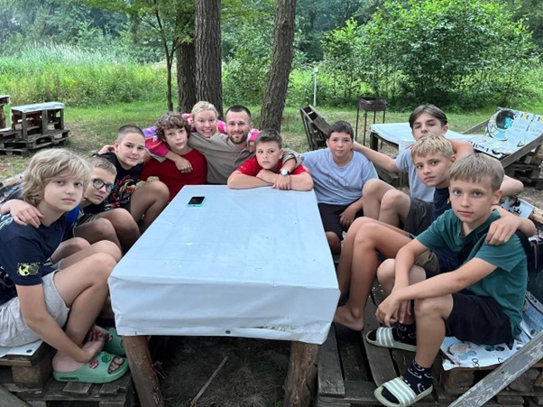 Young Slavic boys joined in community preparing for Summer Camp activities